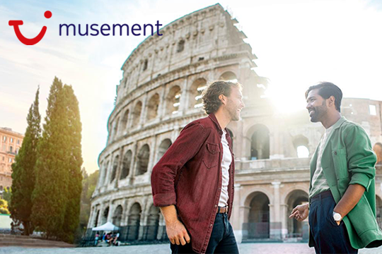 Zwei Männer stehen zueinander gedreht vor dem Kolosseum in Rom